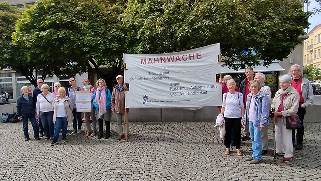 Mahnwache auf dem Spandauer Altmarkt. Die Menschen halten ein Banner: "MAHNWACHE für Toleranz und ein friedliches Miteinander gegen Rassismus, Antisemitismus und Islamfeindlichkeit"