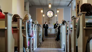 Symbolbild: Gottesdienst in der Dorfkirche Kladow, Menschen sitzen in den Bänken, vorne stehen 2 Pfarrer