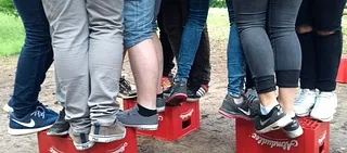 Symbolbild: Jugendliche drängen sich auf Bierkästen