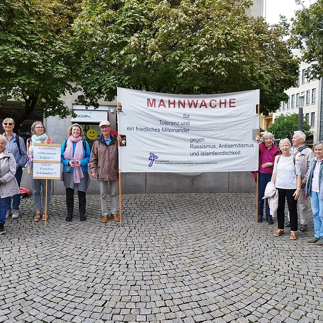 Mahnwache auf dem Spandauer Altmarkt. Die Menschen halten ein Banner: "MAHNWACHE für Toleranz und ein friedliches Miteinander gegen Rassismus, Antisemitismus und Islamfeindlichkeit"