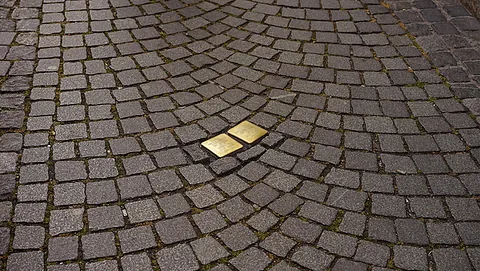 Zwei glänzende Stolpersteine im Straßenpflaster