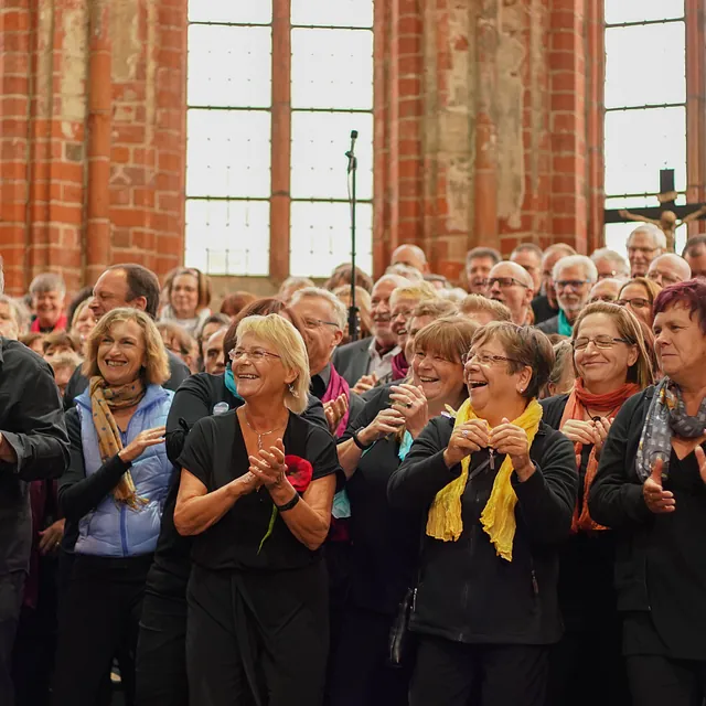 Ein Chor sing und klatscht in einer Kirche.